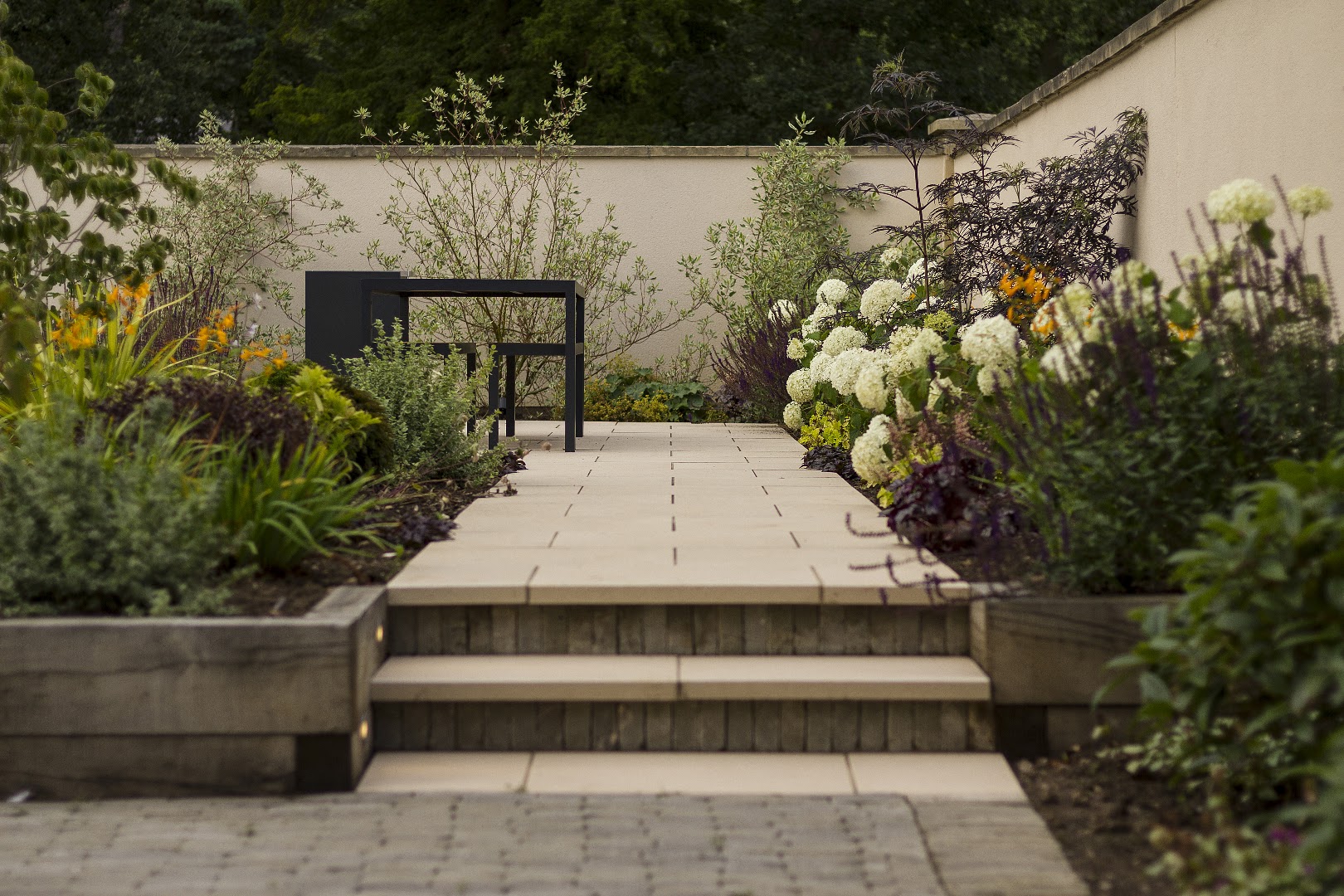 Garden lit at dusk with steps and lighting